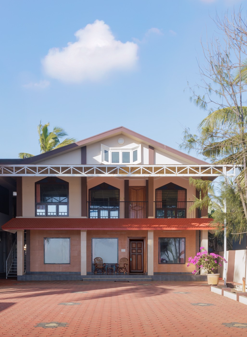 Front of the two-storey villa with balcony and terracotta courtyard